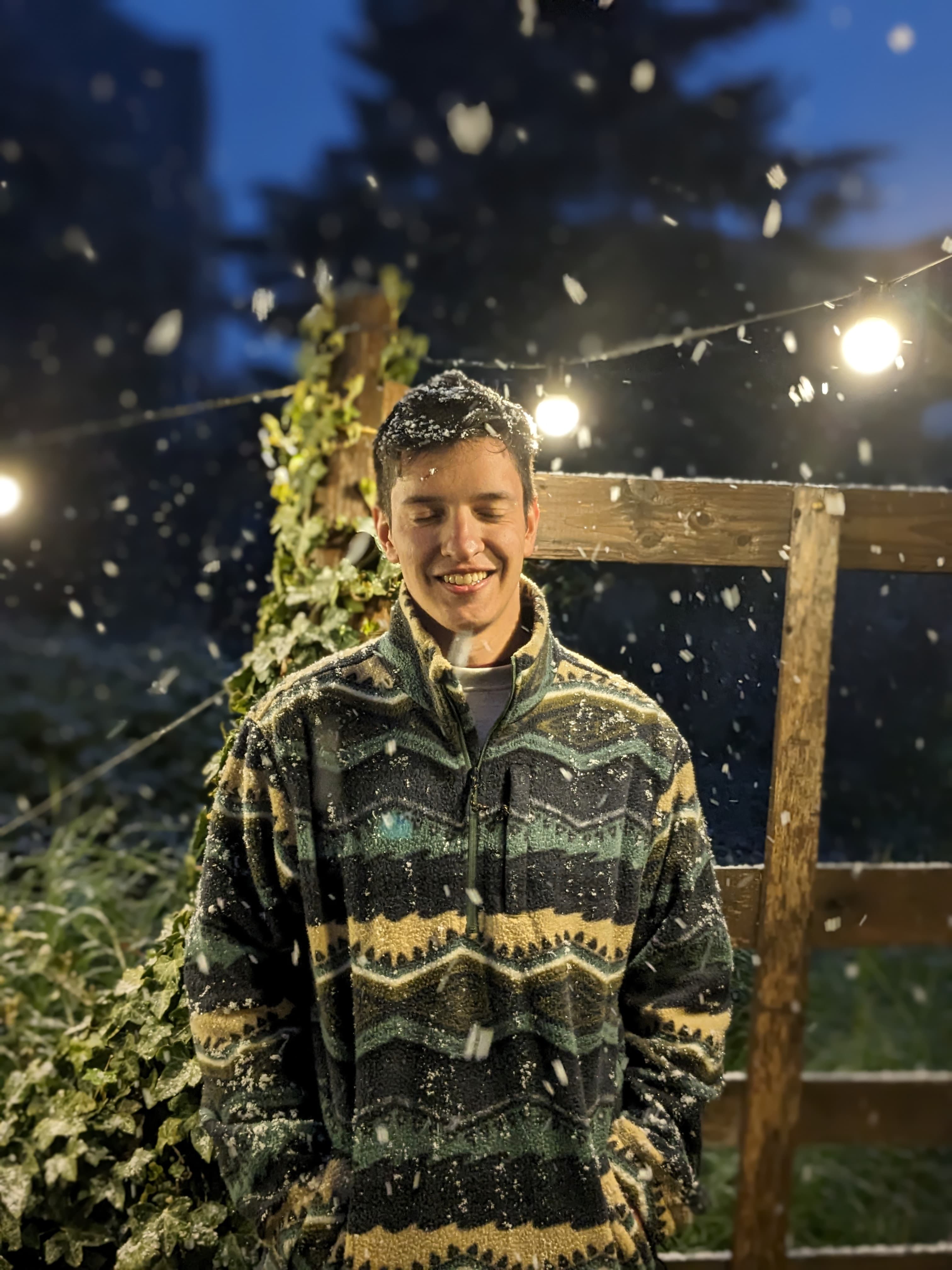 Gabriel Conte Grand outdoors at night, under string lights while it snows